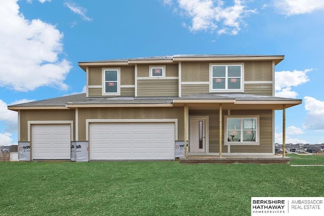 prairie-style home featuring covered porch, a garage, and a front lawn