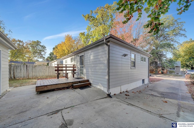 view of property exterior with a patio and a deck