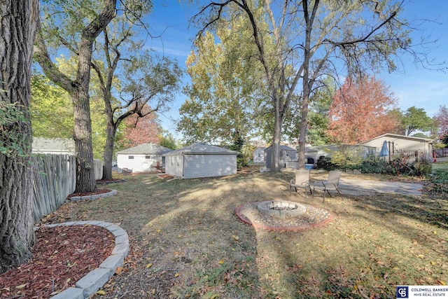 view of yard with a patio, a fire pit, and a storage unit