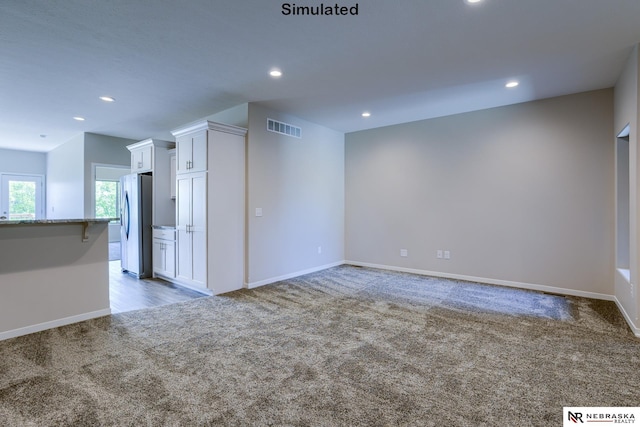 unfurnished living room featuring light colored carpet