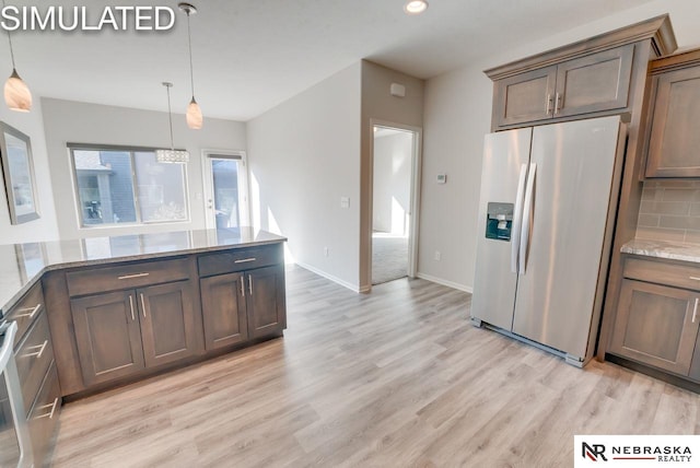 kitchen featuring hanging light fixtures, tasteful backsplash, stainless steel fridge with ice dispenser, light stone counters, and light wood-type flooring