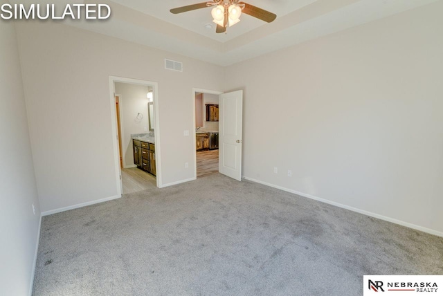 unfurnished bedroom with light carpet, ensuite bathroom, and ceiling fan