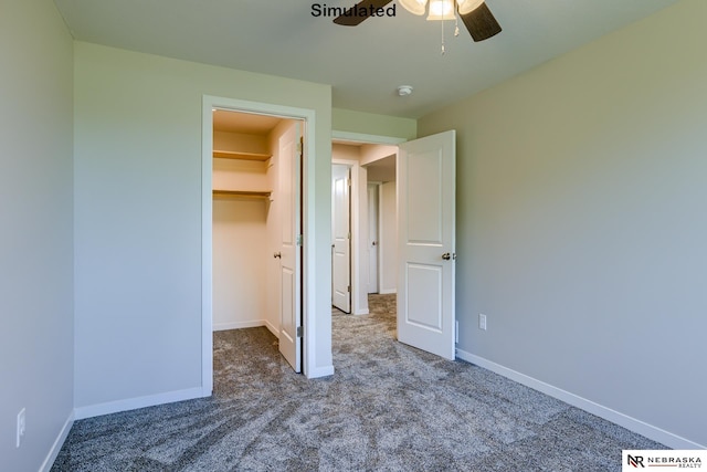 unfurnished bedroom with carpet flooring, a closet, a spacious closet, and ceiling fan