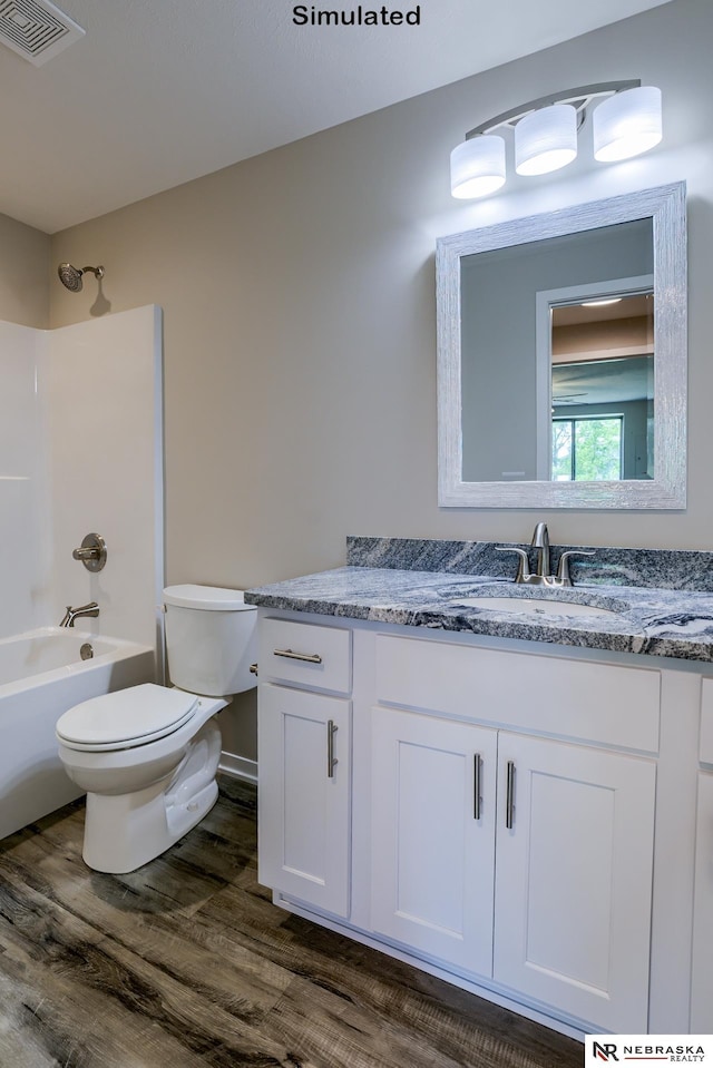 full bathroom featuring hardwood / wood-style floors, vanity, toilet, and tub / shower combination