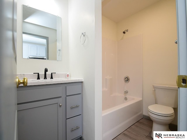 full bathroom featuring hardwood / wood-style floors, vanity, toilet, and shower / bathtub combination