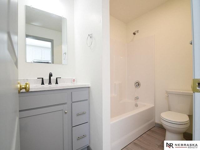 full bathroom with shower / bathing tub combination, wood-type flooring, vanity, and toilet