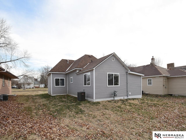 rear view of house with a lawn and central AC