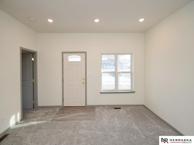 foyer entrance featuring light colored carpet