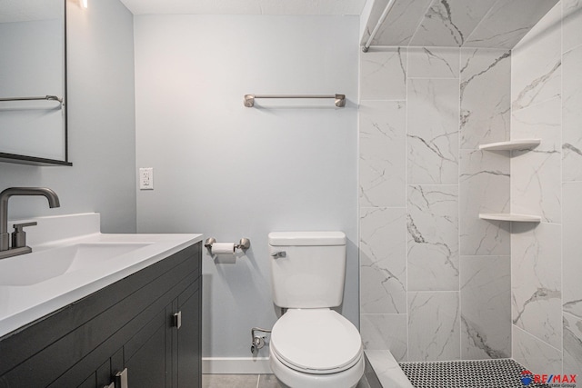 bathroom with tile patterned flooring, a tile shower, vanity, and toilet