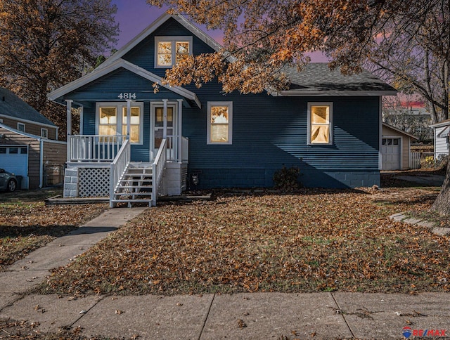 bungalow-style house featuring an outbuilding, covered porch, and a garage