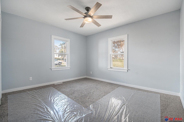 carpeted spare room featuring ceiling fan