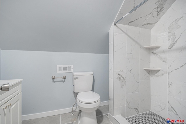 bathroom featuring tile patterned floors, toilet, vanity, and tiled shower