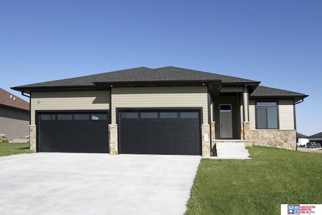 prairie-style home featuring a front yard and a garage