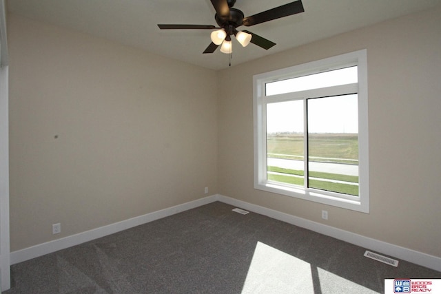 spare room with dark carpet and ceiling fan