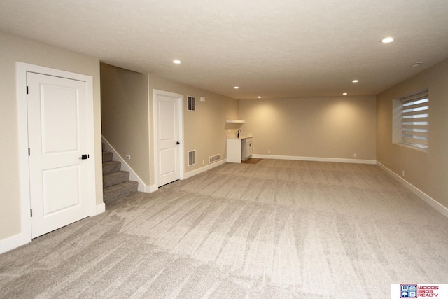 basement featuring light colored carpet