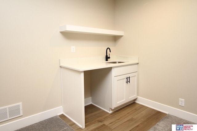 laundry room with sink and wood-type flooring