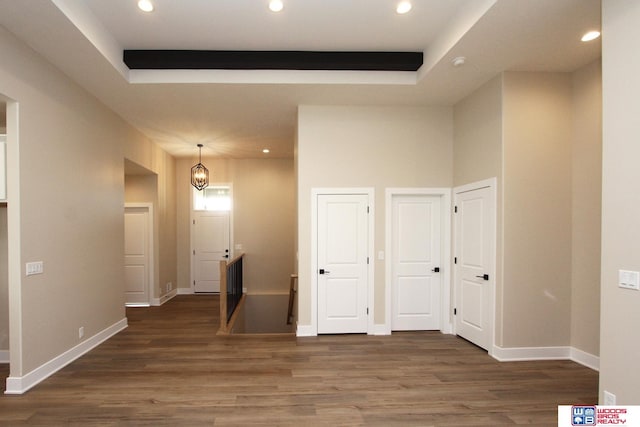 hallway with a chandelier and dark wood-type flooring