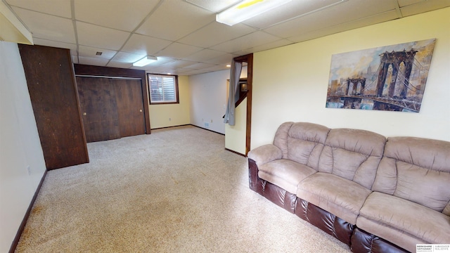 carpeted living room with a paneled ceiling