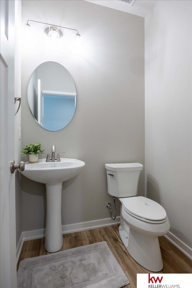 bathroom with wood-type flooring and toilet