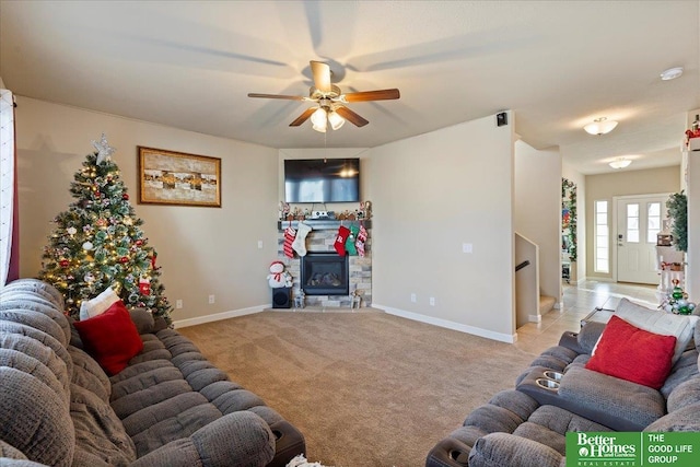 carpeted living room with a fireplace and ceiling fan