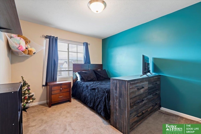 bedroom with light carpet and a textured ceiling