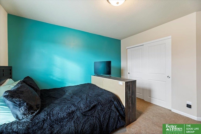 bedroom with light carpet, a textured ceiling, and a closet