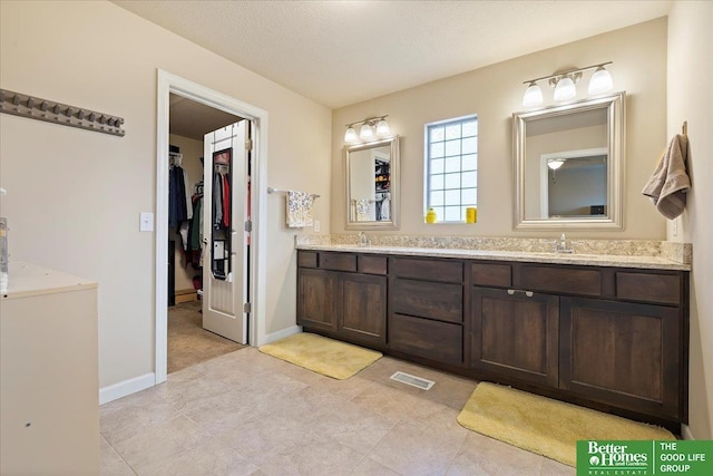 bathroom featuring a textured ceiling and vanity