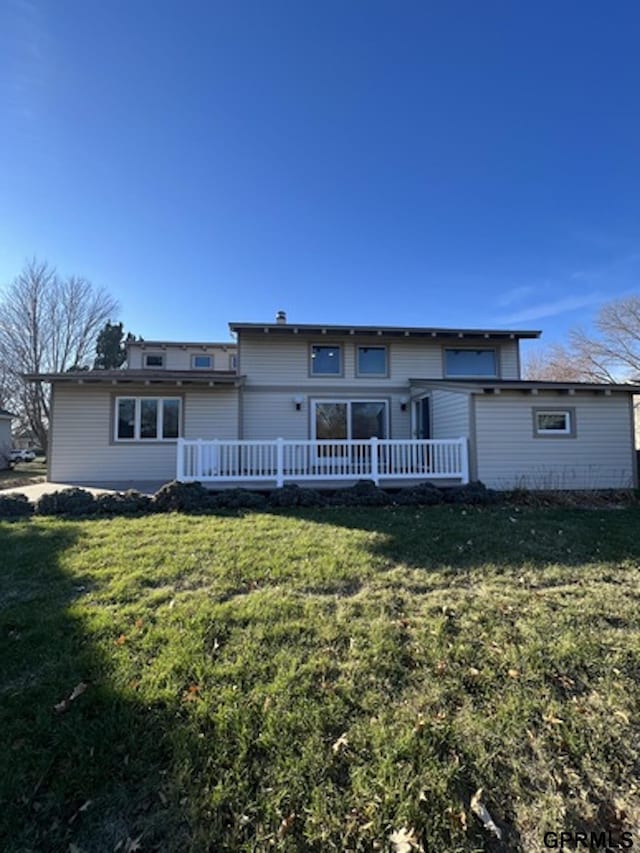 view of front facade with a wooden deck and a front yard