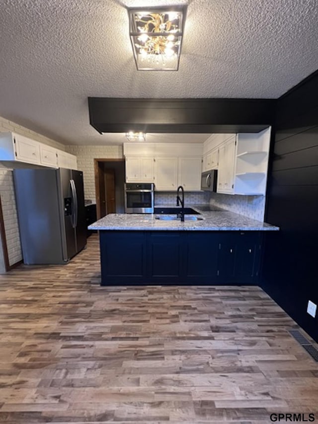 kitchen featuring kitchen peninsula, white cabinetry, sink, and stainless steel appliances