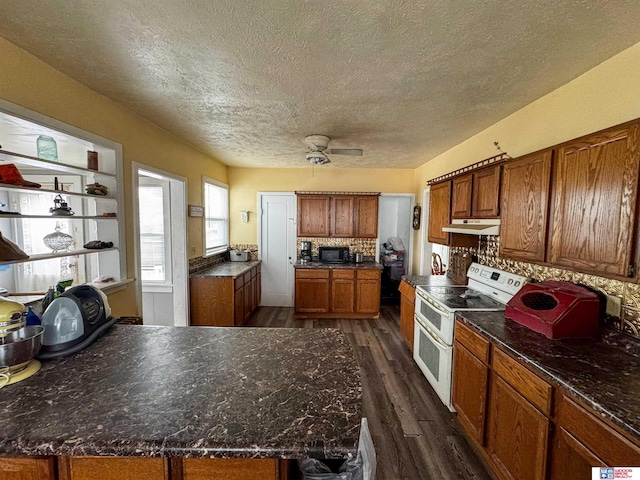 kitchen featuring dark hardwood / wood-style floors, ceiling fan, decorative backsplash, a textured ceiling, and range