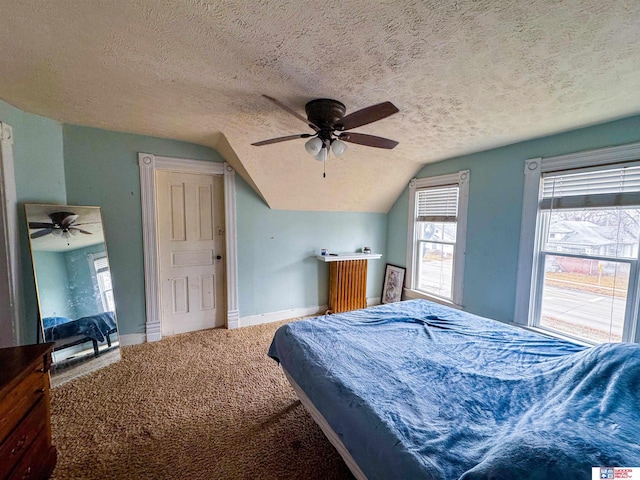 carpeted bedroom with ceiling fan, a textured ceiling, and vaulted ceiling