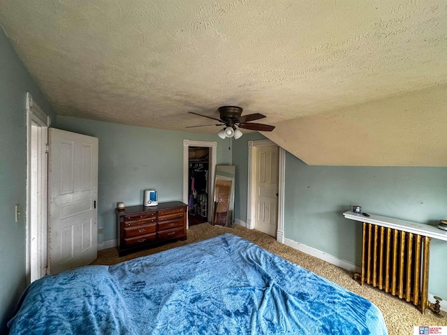 bedroom featuring radiator, ceiling fan, carpet floors, a textured ceiling, and vaulted ceiling