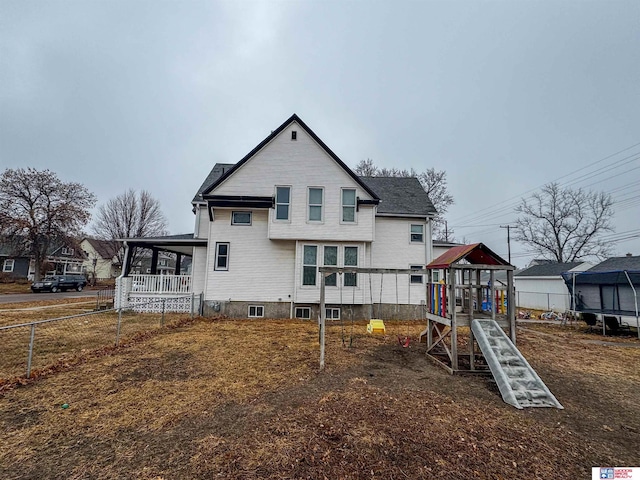 back of house with a playground