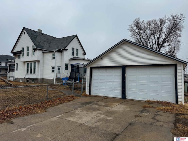 view of property exterior featuring a garage, an outdoor structure, and a trampoline