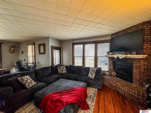 living room featuring hardwood / wood-style flooring and a brick fireplace