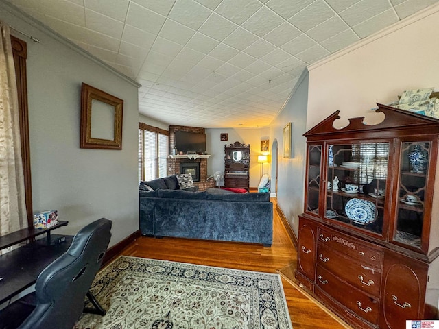 bedroom featuring a fireplace, dark hardwood / wood-style floors, and crown molding