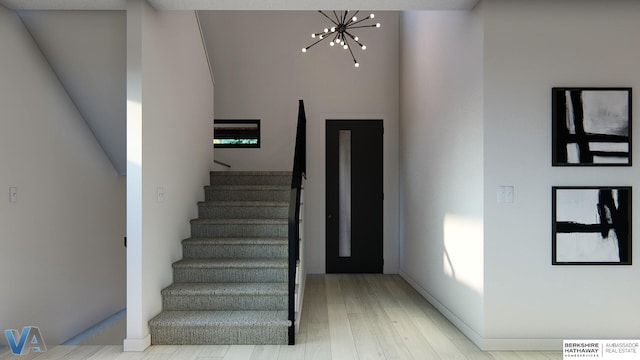 staircase featuring hardwood / wood-style flooring, a high ceiling, and an inviting chandelier