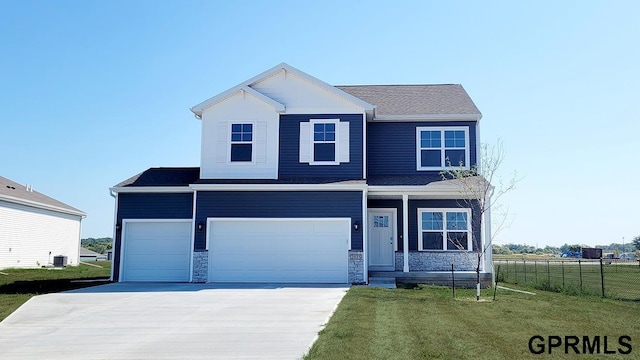 view of front of house featuring central AC unit, a front yard, and a garage