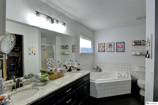 full bathroom featuring tile patterned floors, a textured ceiling, toilet, vanity, and independent shower and bath