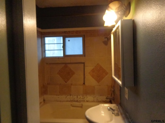 bathroom with tiled shower / bath combo and sink