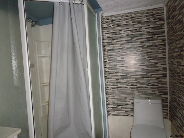 bathroom featuring a shower with shower curtain, a textured ceiling, and toilet