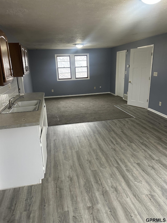 kitchen with hardwood / wood-style flooring, dark brown cabinetry, and sink