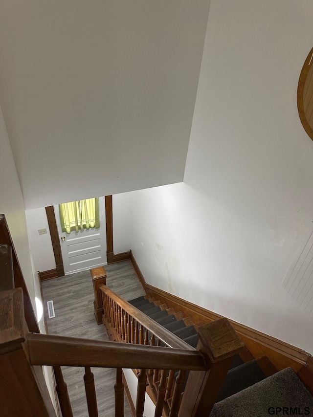 stairs featuring hardwood / wood-style flooring and wood walls