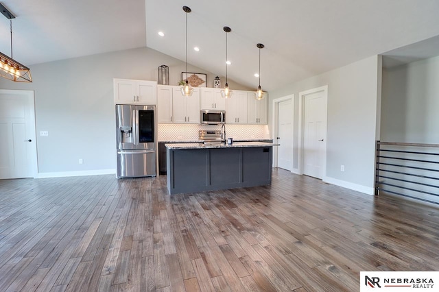 kitchen featuring white cabinets, an island with sink, decorative light fixtures, and appliances with stainless steel finishes