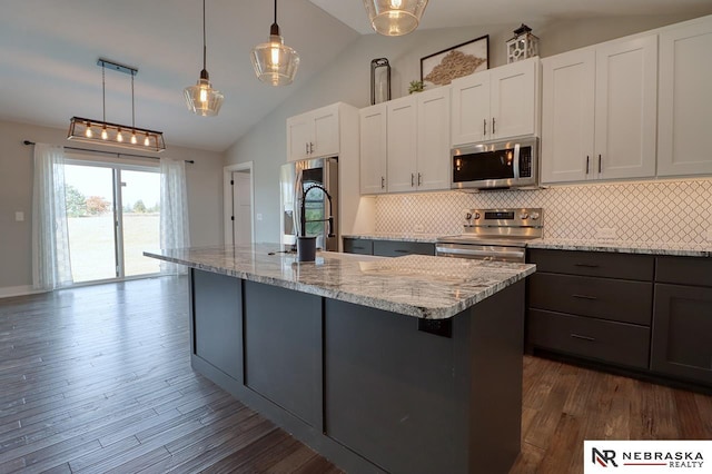 kitchen featuring appliances with stainless steel finishes, light stone counters, dark hardwood / wood-style floors, white cabinetry, and lofted ceiling