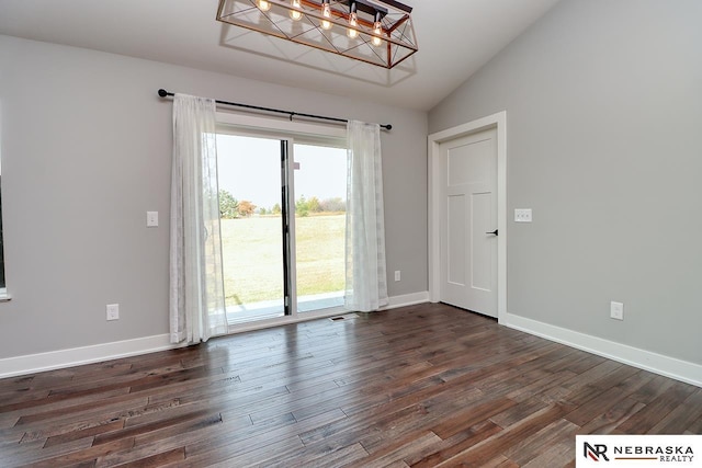 empty room featuring dark hardwood / wood-style flooring and lofted ceiling