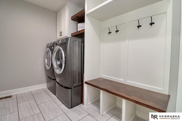 washroom featuring separate washer and dryer and cabinets