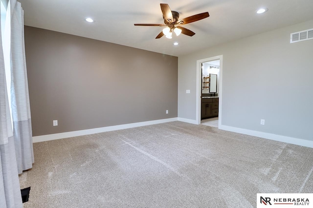 spare room with ceiling fan and light carpet