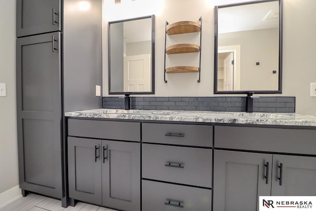 bathroom with vanity and tasteful backsplash