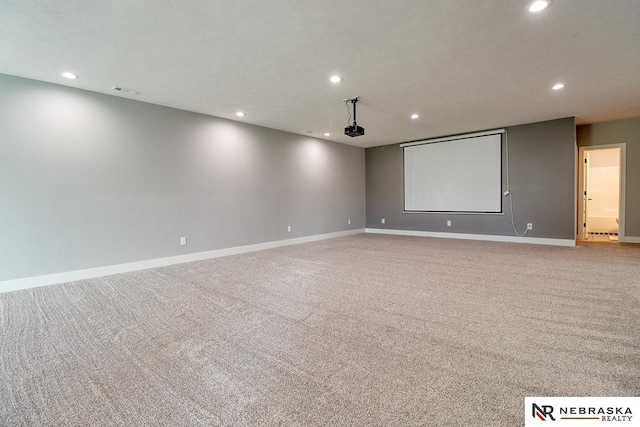 cinema room with a textured ceiling and light colored carpet